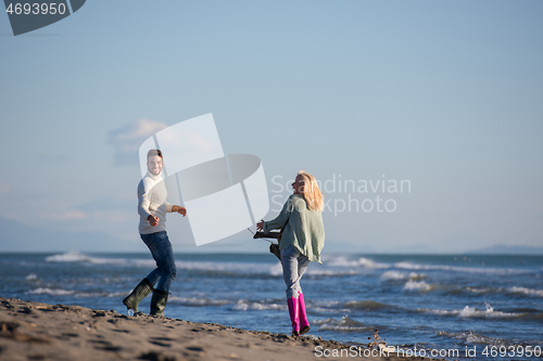 Image of Loving young couple on a beach at autumn sunny day