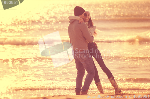 Image of Loving young couple on a beach at autumn sunny day