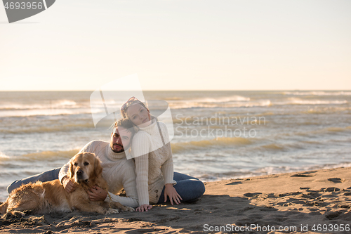 Image of Couple with dog enjoying time on beach