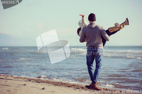 Image of Loving young couple on a beach at autumn sunny day