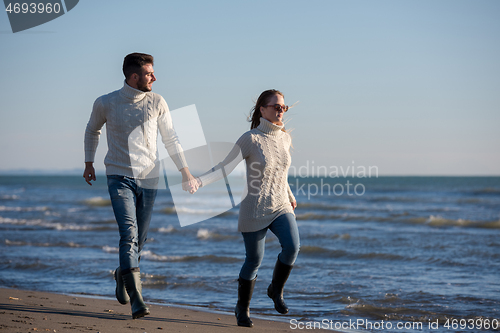 Image of Loving young couple on a beach at autumn sunny day