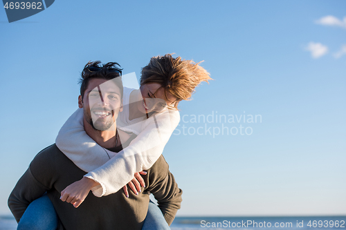 Image of couple having fun at beach during autumn