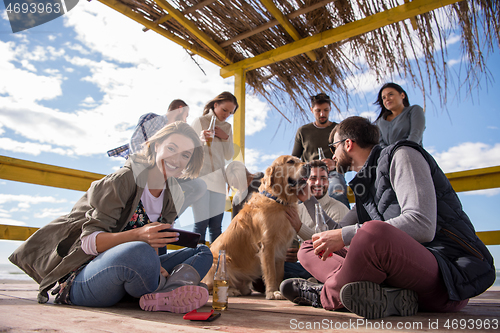 Image of Group of friends having fun on autumn day at beach