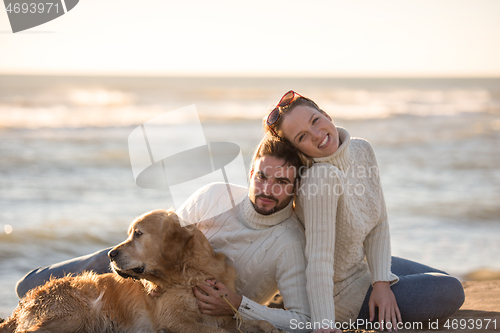 Image of Couple with dog enjoying time on beach