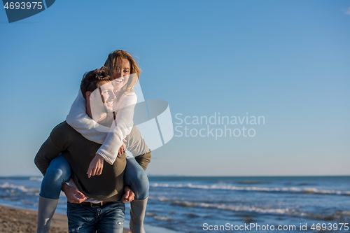 Image of couple having fun at beach during autumn