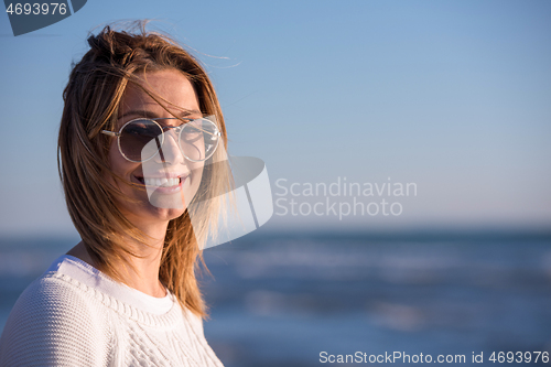 Image of Young woman enjoying the warm autumn day