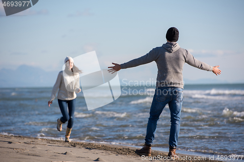 Image of Loving young couple on a beach at autumn sunny day