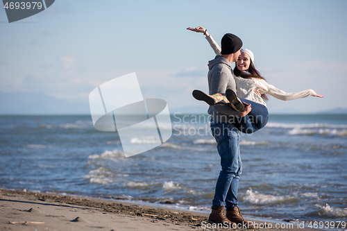 Image of Loving young couple on a beach at autumn sunny day