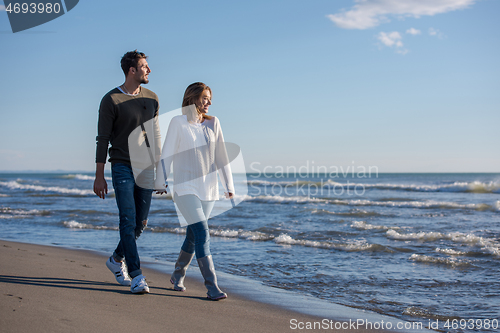 Image of Loving young couple on a beach at autumn sunny day