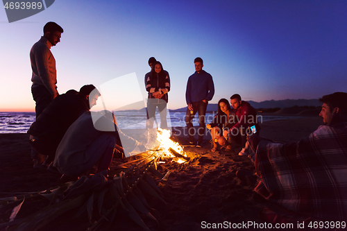 Image of Friends having fun at beach on autumn day