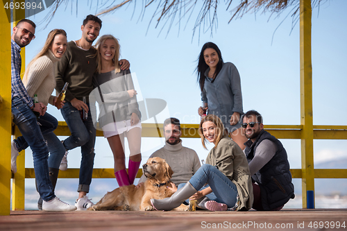 Image of Group of friends having fun on autumn day at beach