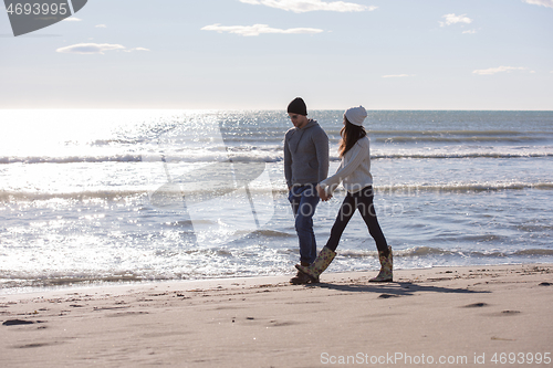 Image of Loving young couple on a beach at autumn sunny day