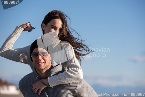 Image of couple having fun at beach during autumn