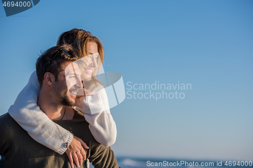 Image of couple having fun at beach during autumn