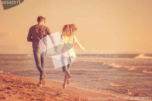 Image of Loving young couple on a beach at autumn sunny day