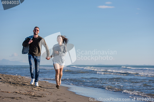 Image of Loving young couple on a beach at autumn sunny day