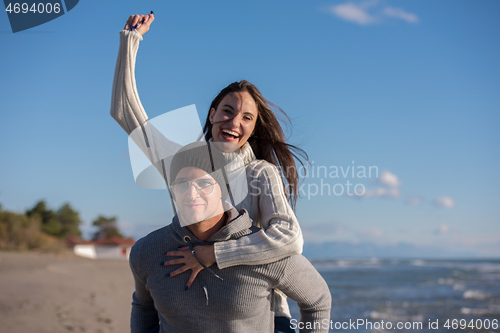 Image of couple having fun at beach during autumn