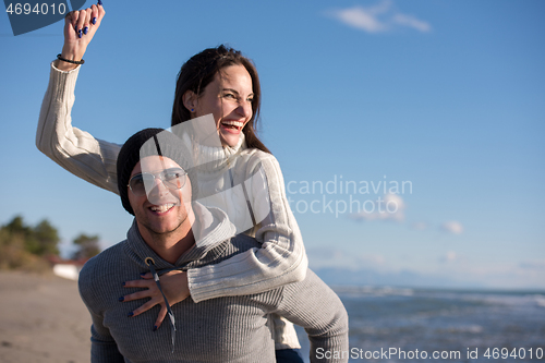 Image of couple having fun at beach during autumn