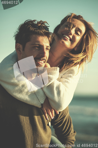 Image of couple having fun at beach during autumn