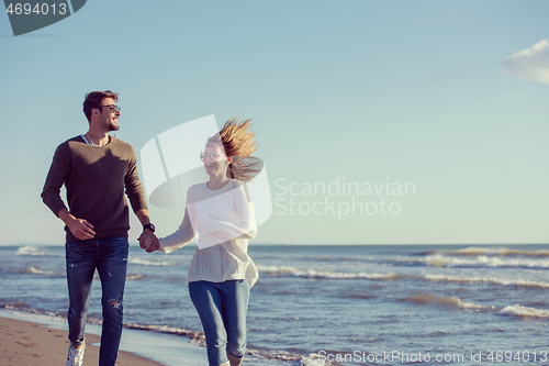 Image of Loving young couple on a beach at autumn sunny day