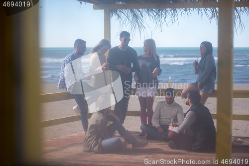 Image of Group of friends having fun on autumn day at beach