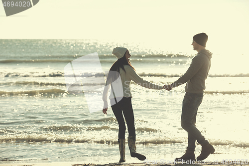 Image of Loving young couple on a beach at autumn sunny day