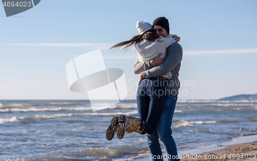 Image of Loving young couple on a beach at autumn sunny day