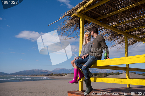 Image of young couple drinking beer together at the beach