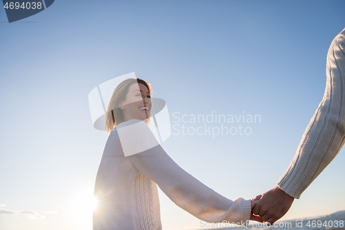 Image of Loving young couple on a beach at autumn sunny day