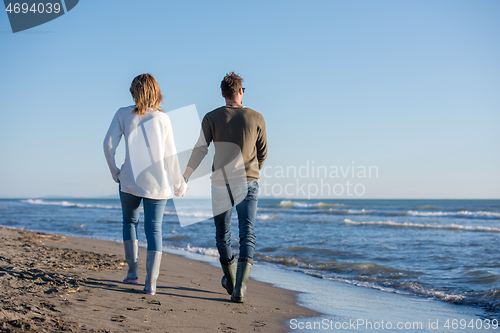 Image of Loving young couple on a beach at autumn sunny day