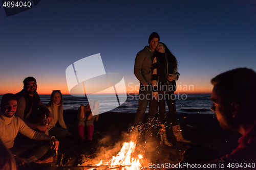 Image of Friends having fun at beach on autumn day