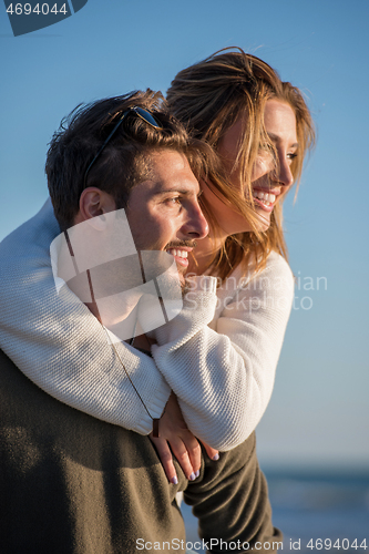 Image of couple having fun at beach during autumn