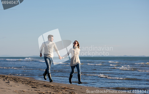 Image of Loving young couple on a beach at autumn sunny day