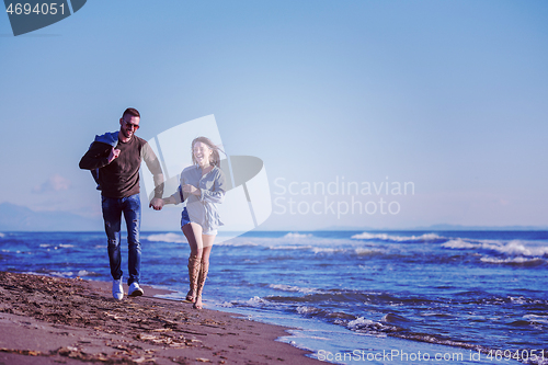 Image of Loving young couple on a beach at autumn sunny day