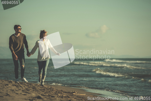 Image of Loving young couple on a beach at autumn sunny day