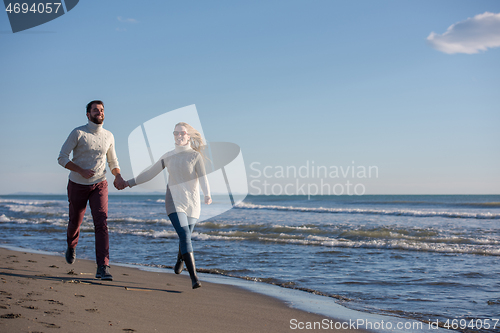 Image of Loving young couple on a beach at autumn sunny day