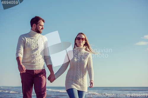 Image of Loving young couple on a beach at autumn sunny day