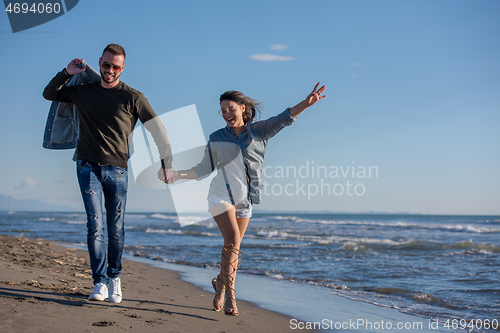 Image of Loving young couple on a beach at autumn sunny day