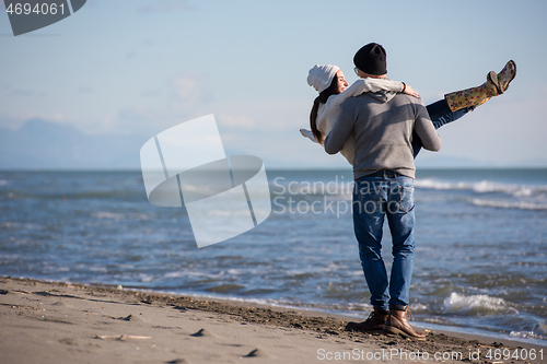 Image of Loving young couple on a beach at autumn sunny day