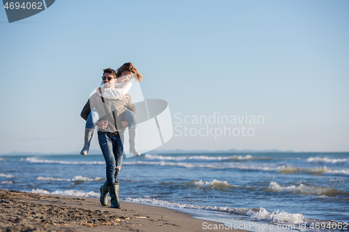 Image of couple having fun at beach during autumn