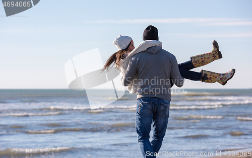 Image of Loving young couple on a beach at autumn sunny day