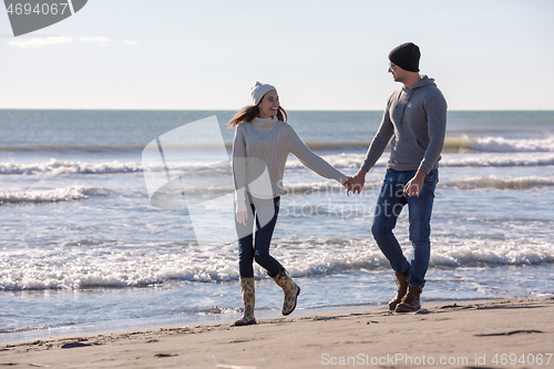 Image of Loving young couple on a beach at autumn sunny day