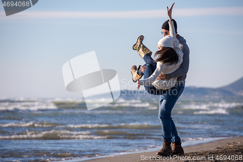 Image of Loving young couple on a beach at autumn sunny day