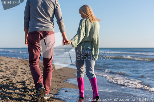 Image of Loving young couple on a beach at autumn sunny day