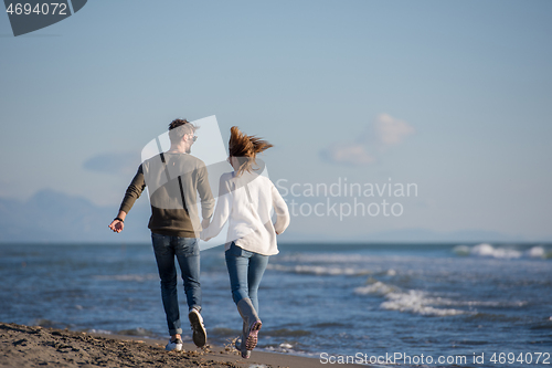 Image of Loving young couple on a beach at autumn sunny day