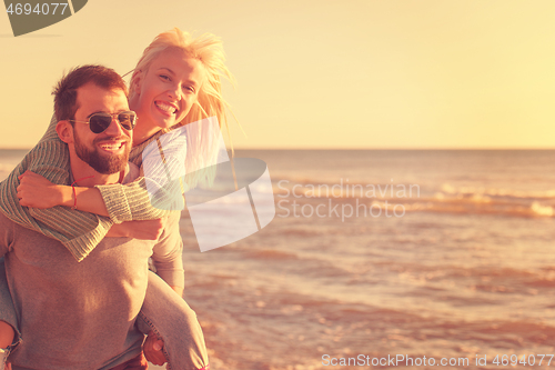 Image of couple having fun at beach during autumn