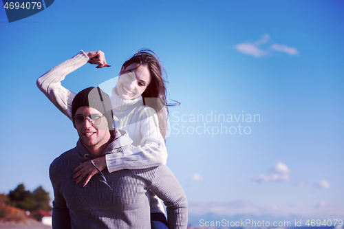 Image of couple having fun at beach during autumn