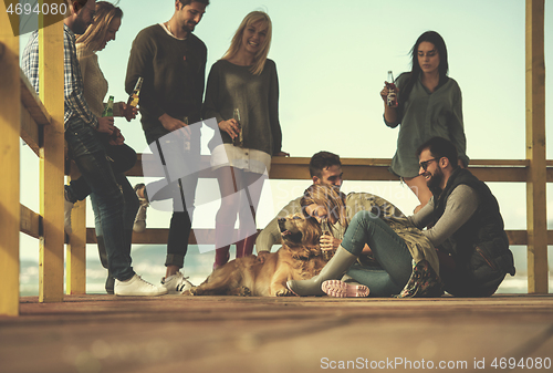Image of Group of friends having fun on autumn day at beach