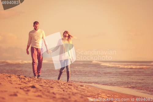 Image of Loving young couple on a beach at autumn sunny day