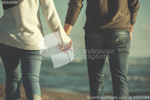 Image of Loving young couple on a beach at autumn sunny day